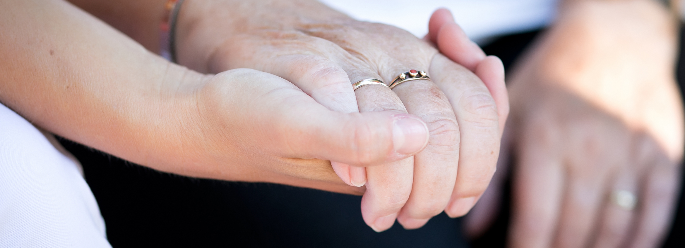 Verantwortung der Burchard Führer GmbH Eine Hand einer Pflegerin hält die hand einer Seniorin